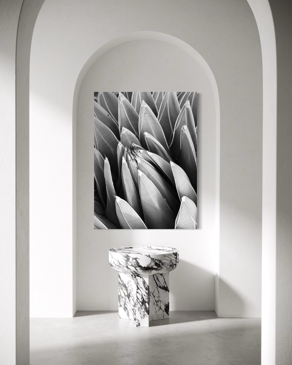 Large monochrome desert form displayed within a soft stone arch, creating a sculptural, serene focal point.