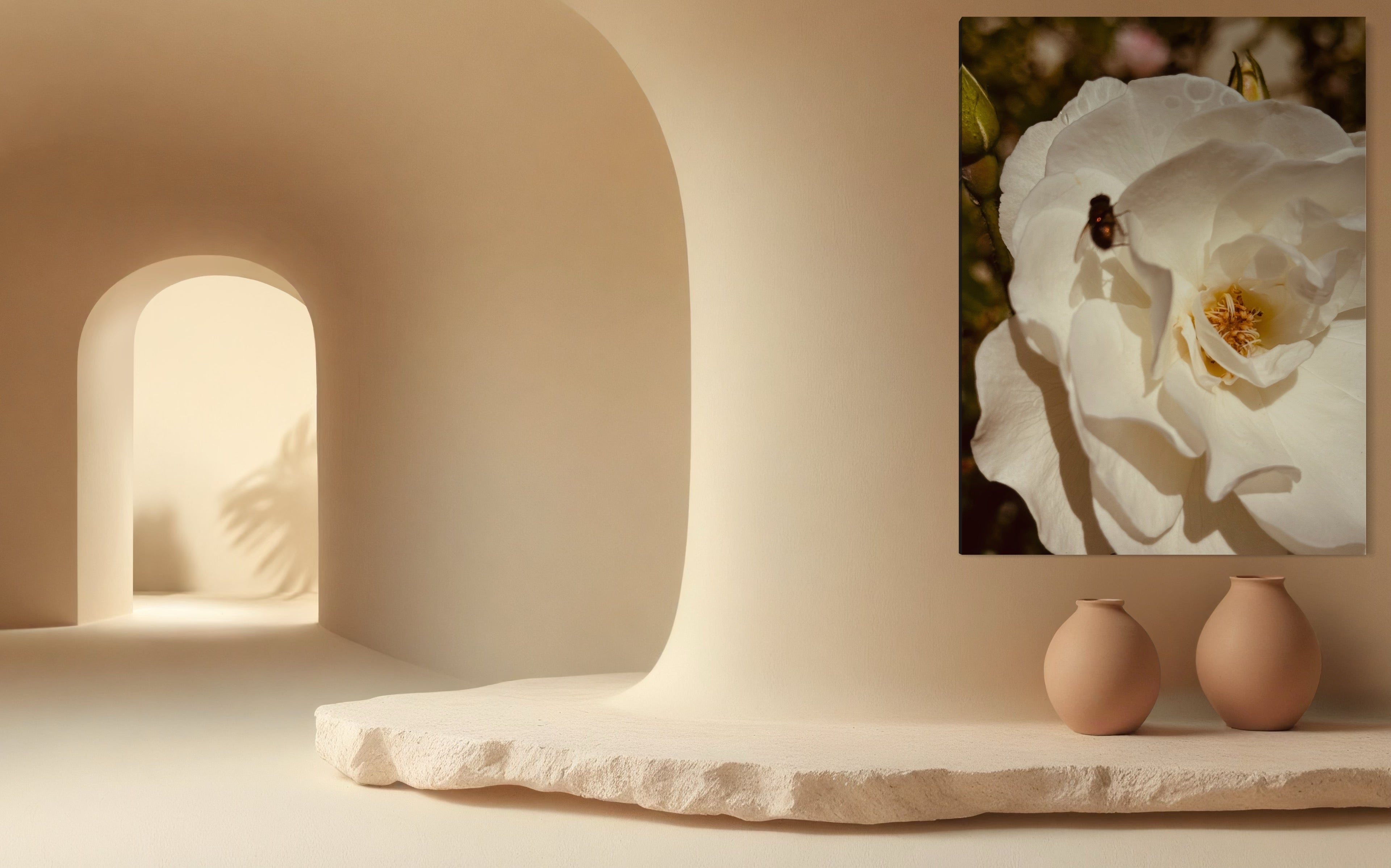 White rose artwork with a small fly styled above a stone ledge with minimalist clay vases in a warm neutral space